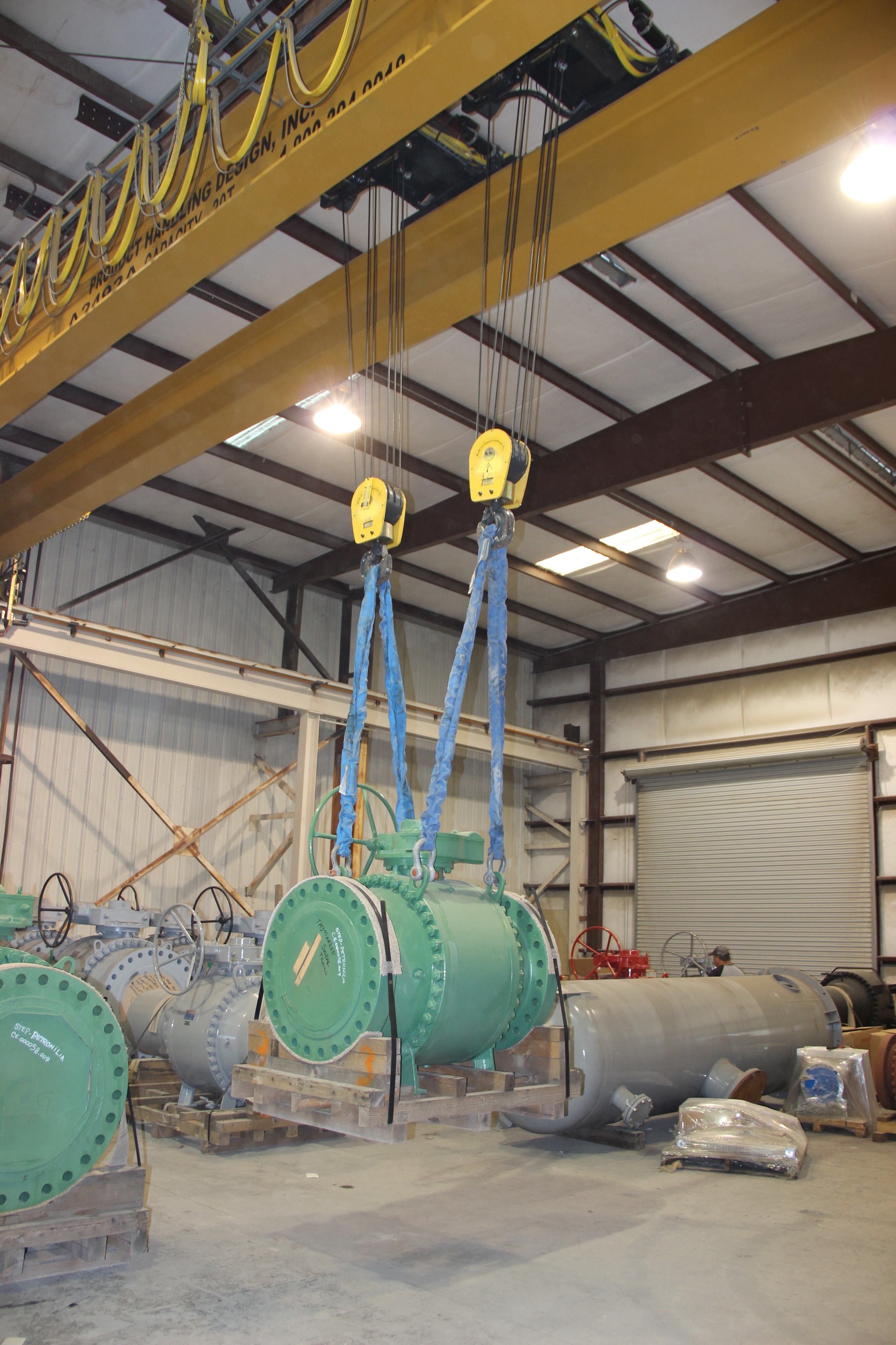 Overhead crane lifting industrial equipment inside Palletized warehouse